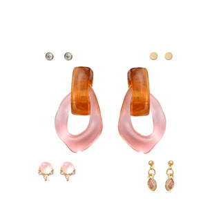Five-piece earring set featuring bold translucent orange and pink acrylic hoops, sparkling crystal studs, gold-tone textured studs, pink gem drops, and marquise-cut pink crystal dangles, packaged in a gift box.