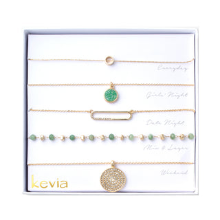 Gold necklace set with sea glass and green tourmaline beads, druzy charm, minimalist circle, pavé link, and mandala medallion.