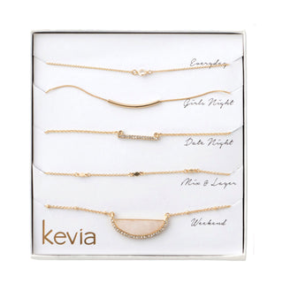 Five-piece gold necklace set featuring rose quartz half-moon pendant, crystal accents, and curved bar charms