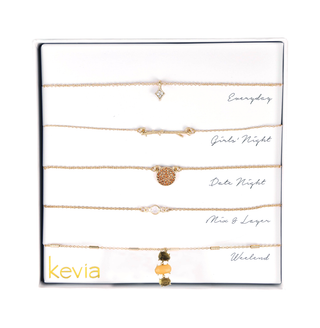 Five-piece gold necklace set featuring branch charm, pavé disc, smoky quartz accents, and citrine bead strands, packaged in a gift box.