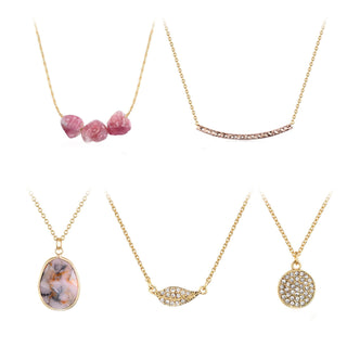 Five-piece gold-tone necklace set with pink stone trio, textured curved bar, marbled natural stone pendant, crystal leaf, and pavé circle charm.