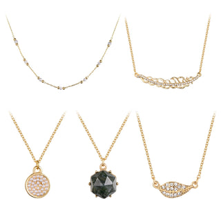 Five-piece gold necklace set featuring a dark green faceted stone, pearl accents, hammered bar, crystal leaf pendant, and gold-plated chains.