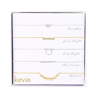 Five-piece gold and silver-tone necklace set featuring a crystal heart pendant, pavé bar necklace, crystal circle pendant, hammered silver bar, and gold-tone fringe chain.