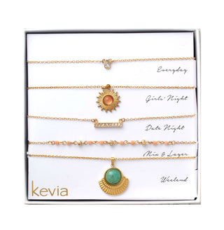 Five-piece gold necklace set with sunburst charm, turquoise fan pendant, and peach-toned bead accents, packaged in a gift box.