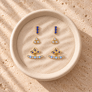 Gold earring set with blue bar studs, crystal cluster studs and opal-accented fan earring jackets.