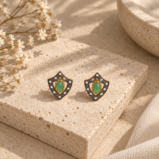 Shield-shaped stud earrings with green oval stones, gold accents and clear crystals.