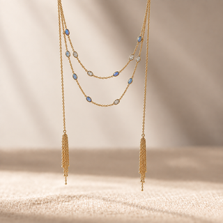 Gold layered lariat necklace with blue opal accents and two long chain tassels.