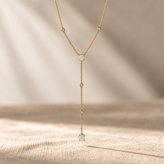 Delicate gold Y-shaped necklace with opals and small crystal accents.