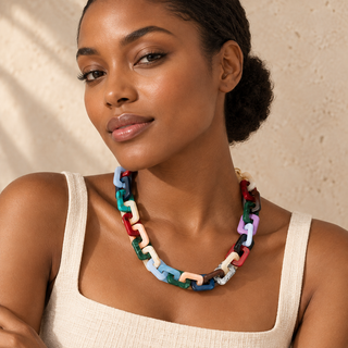 Model wearing chunky necklace with multicolored rectangular resin links and a gold chain clasp.