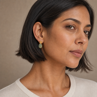 Model wearing gold pineapple stud earrings with turquoise bead accents.