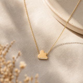 Gold chain necklace with a cloud pendant and crystal accents along the bottom.