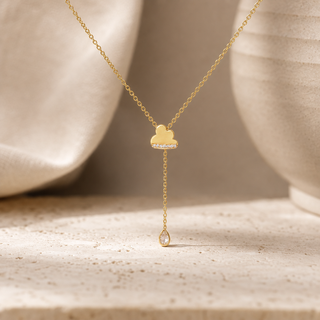 Gold Y-shaped necklace with a cloud charm and a long chain ending in a teardrop crystal pendant.