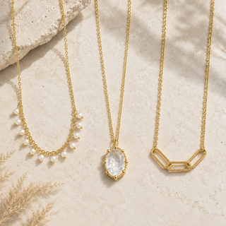 Crystal Glow layered gold necklace set styled on warm stone