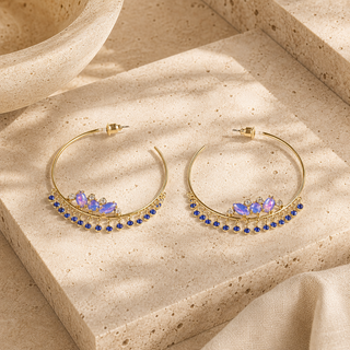 Gold hoop earrings with opal clusters and dangling sapphire blue crystal charms.