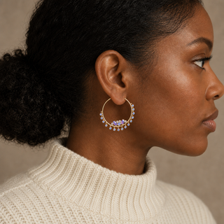 Model wearing gold hoop earrings with iridescent opal clusters and dangling round opal charms.