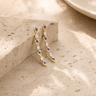 Curved gold drop earrings with alternating blue opal and clear crystal accents.