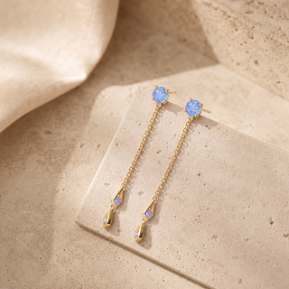 Gold double chain drop earrings with blue opal studs and geometric opal pendants.