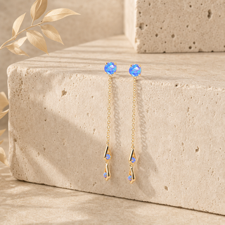 Gold double chain drop earrings with blue opal studs and geometric opal pendants.