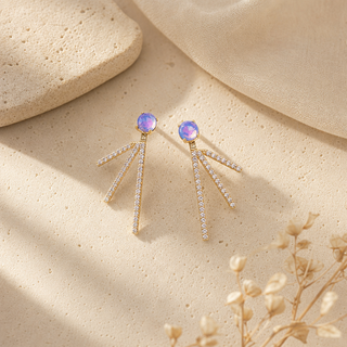 Gold drop earrings with opal studs and three splayed crystal-accented bars.