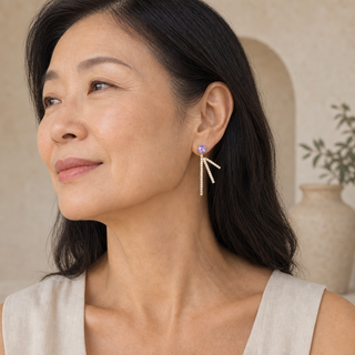 Model wearing gold drop earrings with opal studs and three splayed crystal-accented bars.