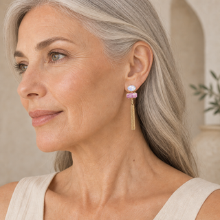 Model wearing gold chain tassel drop earrings with blue oval and pink rectangular opals.
