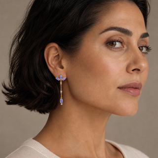 Model wearing gold chain drop earrings with marquise opal clusters and single opal pendants.