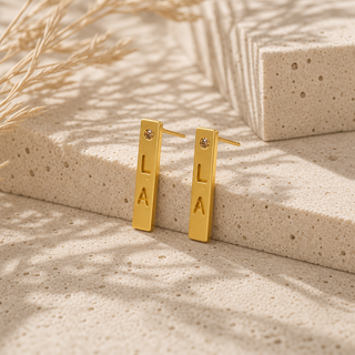 Gold LA bar stud earrings with small crystal accents.