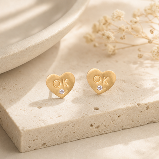 Gold heart stud earrings stamped OK with small crystal accents.