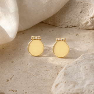 Gold round ornament stud earrings with crystal-accented tops.