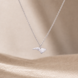 Silver chain necklace with a North Carolina-shaped pendant and a small crystal accent.