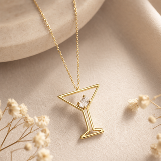 Gold chain necklace with an open martini glass pendant and small crystal accents.