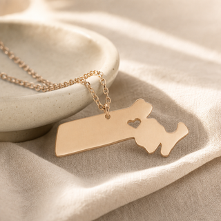 Rose gold chain necklace with a Massachusetts state pendant and a heart cutout.