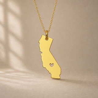 Gold chain necklace with a California state pendant and a heart cutout.