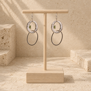 Silver oval drop earrings with hammered open oval tops, small green stones and thin oval drops.