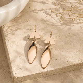 Rose gold geometric drop earrings with semicircle tops and long open marquise pendants.