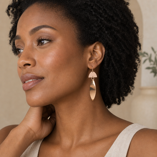 Model wearing rose gold geometric drop earrings with semicircle tops and long open marquise pendants.