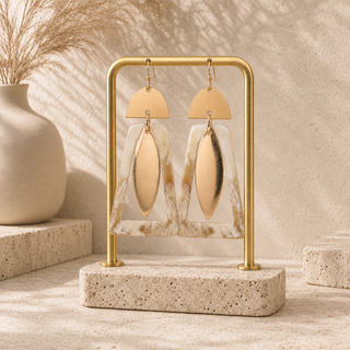gold and natural horn drop earrings with semicircle tops, open horn frames and long marquise pendants. displayed on a gold framed holder