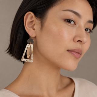 Model wearing gold and natural horn drop earrings with semicircle tops, open horn frames and long marquise pendants.
