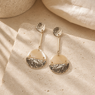 Gold drop earrings with hammered round studs and round horn pendants partly covered with hammered metal.