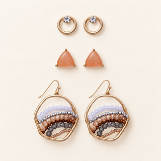 Three pairs of gold earrings with ombre bead circles, peach triangular stone studs, and small crystal-accented open circles on cream.